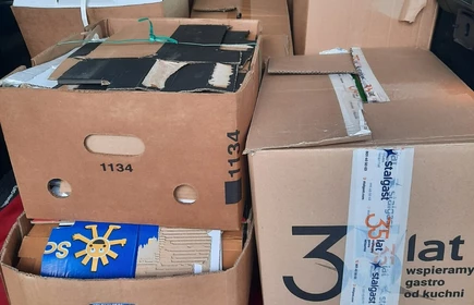 na zdjeciu widać duże kartonowe pudełka  ułożone w wewnątrz samochodu