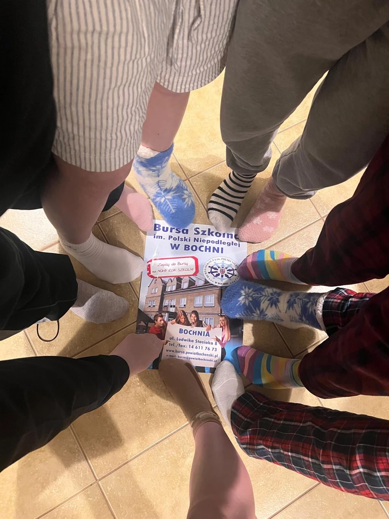  na zdjęciu widać kolorowe, niepasujące skarpetki zostały założone z okazji Światowy Dzień Zespołu Downa. To symbol akceptacji, solidarności i wsparcia dla osób z zespołem Downa ????. Zdjęcie ma przyjazny i pozytywny charakter, pokazujący wspólne zaangażowanie i dobrą atmosferę.
