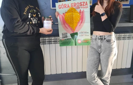 dwie uczennice stojące z plakatem