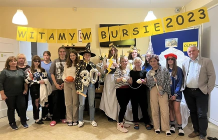 uczniowie i nauczyciele stojący podczas zabawy na świetlicy w bursie