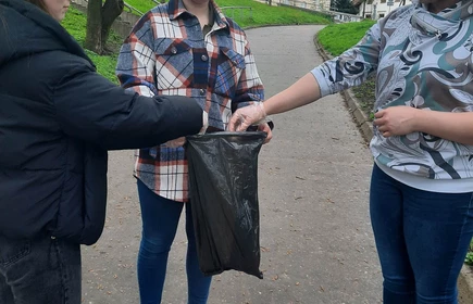 uczennice wrzycają do worka śnieci