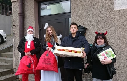 uczniowie i nauczyciel prze budynkiem domu dziecka