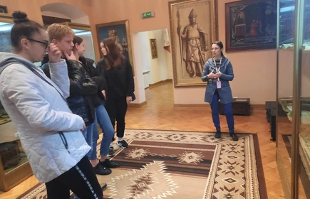 uczniowie słuchają pani przewodnik w muzeum