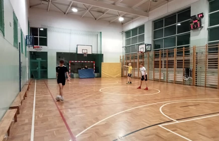 uczniowie grający w piłkę na sali gimnastycznej