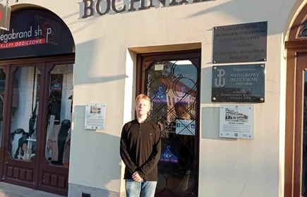 uczeń stojący przed Domem Bochniaków