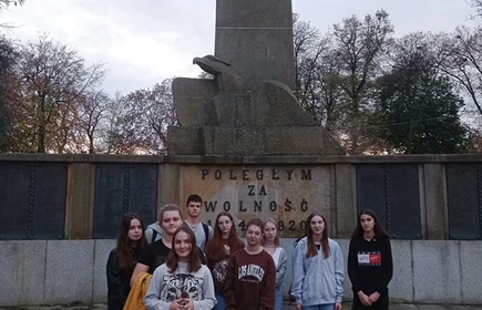 uczniowie stojący przed pomnikiem żołniezy na plantach
