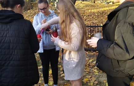uczniowie zapalają świece na pomnik