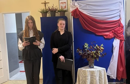 uczeń i uczennica stojący na tle flagi Plski
