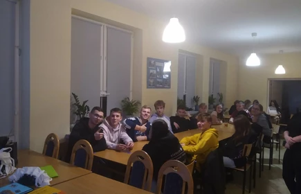 Uczniowie uczestniczący w spotkaniu siedzący przy stołach