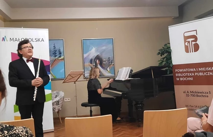pani grająca na pianinie i mężczyzna stojący z instrumentem muzycznym
