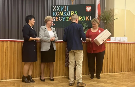 organizatorzy konkursu wręczają uczniowi nagrodę