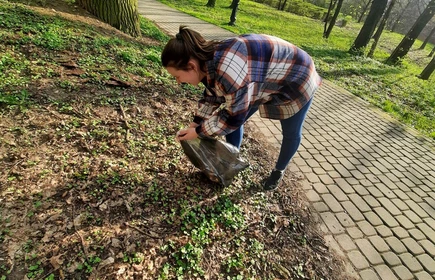 uczennica zbiera śmieci z trawnika