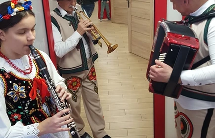 Uczniowie pzebrani w stroje ludowe grają na instrumentach