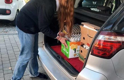uczeń układający makulaturę w samochodzie