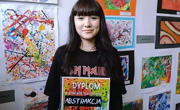 Uczennica trzymająca w rękach dyplom 