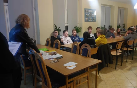Uczniowie uczestniczący w spotkaniu siedzący przy stołach