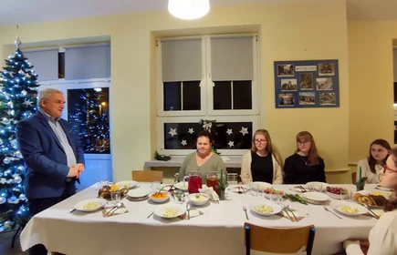 uczniowie podczas kolacji wigilijnej, dyreltor skłąda życzenia