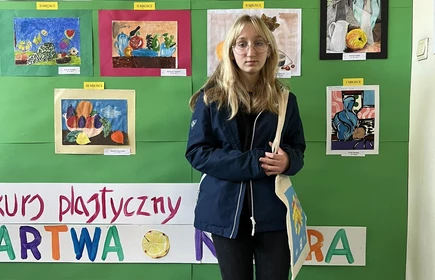 uczennica stojąca na tle obrazów