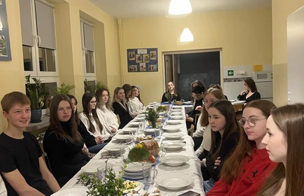 uczniowie siedzący przy stole podczas kolacji wielkanocnej