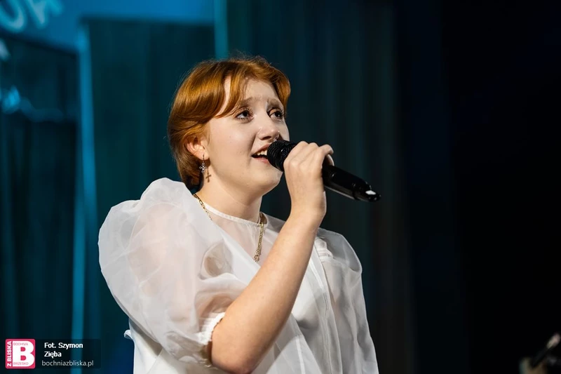 na zdjęciu widać dziewczynę trzymającą w ręku mikrofon