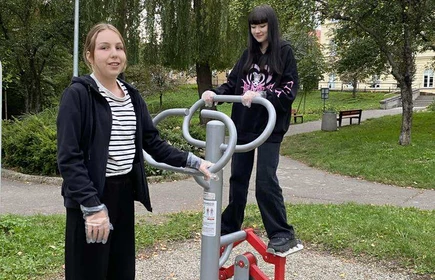 Dwie stojące uczennice obok sprzętu sportowego w Parku