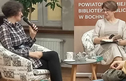 uczestnicy spotkania siedzący na krzesłąch w sali biblioteki