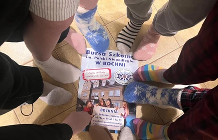  na zdjęciu widać kolorowe, niepasujące skarpetki zostały założone z okazji Światowy Dzień Zespołu Downa. To symbol akceptacji, solidarności i wsparcia dla os&oacute;b z zespołem Downa ????. Zdjęcie ma przyjazny i pozytywny charakter, pokazujący wsp&oacute;lne zaangażowanie i dobrą atmosferę.