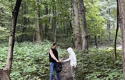 Uczniowie sprzątający i zbierający śmieci w lesie