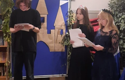 Dwie uczennice i uczeń, wychowankowie bursy podczas występu artystycznego z okazji uroczystości „Witamy w Bursie”. W bajkowej scenerii, w rolach króla, królowej i dwórek, zaprezentowali program powitalny dla nowych mieszkańców placówki.