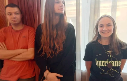 trzech uczniów stojących przy oknie
