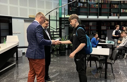 uczeń przyjmuje gratulacje od organizatora turnieju szachowego