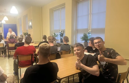 uczniowie siedzący za stołem podczas zajęć