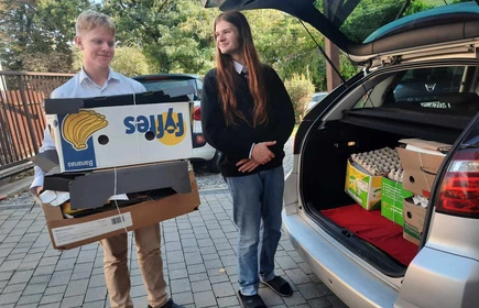 uczniowie pakujący makulaturę do samochodu