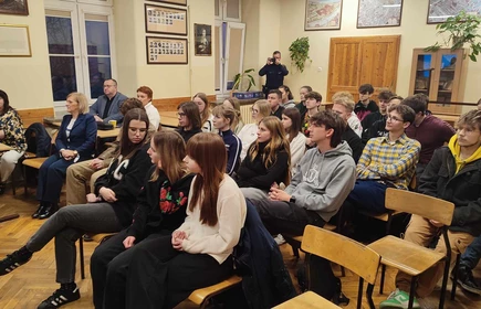 siedzący na krzesłach uczniowie i uczennice słuchający prelekcji o bezpieczeństwie