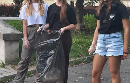 trzy uczennice zbierające śmieci w parku