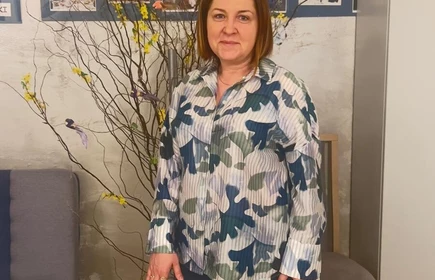 Na zdjęciu widać osobę kobietę ,kt&oacute;ra stoi przed stołem na kt&oacute;rym z zeton&oacute;w ułożone jest serce z okrągłych żeton&oacute;w a obok są ułożone kolorowe karty 