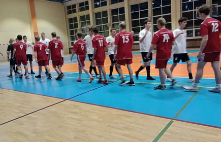 uczniowie przed roapoczęciem meczu witają się na sali gimnastycznej